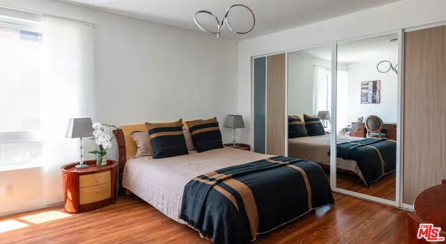 a bedroom with bed and wooden floor