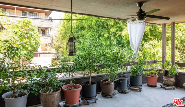 a view of a balcony with chair and potted plants