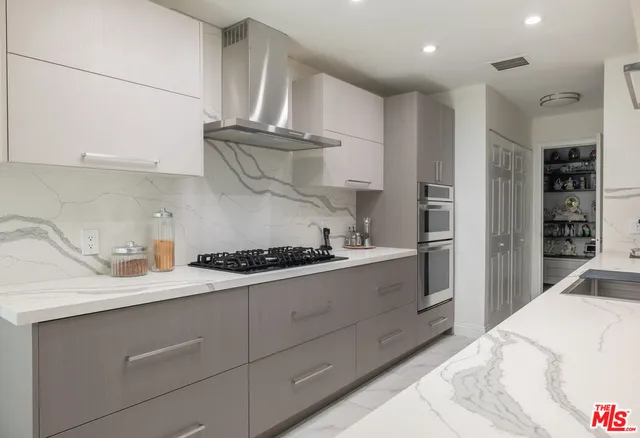 a kitchen with kitchen island granite countertop a sink stainless steel appliances and cabinets