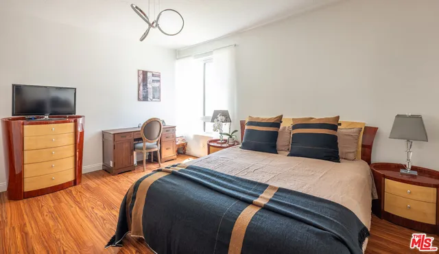 a bedroom with a bed and tv on the dresser