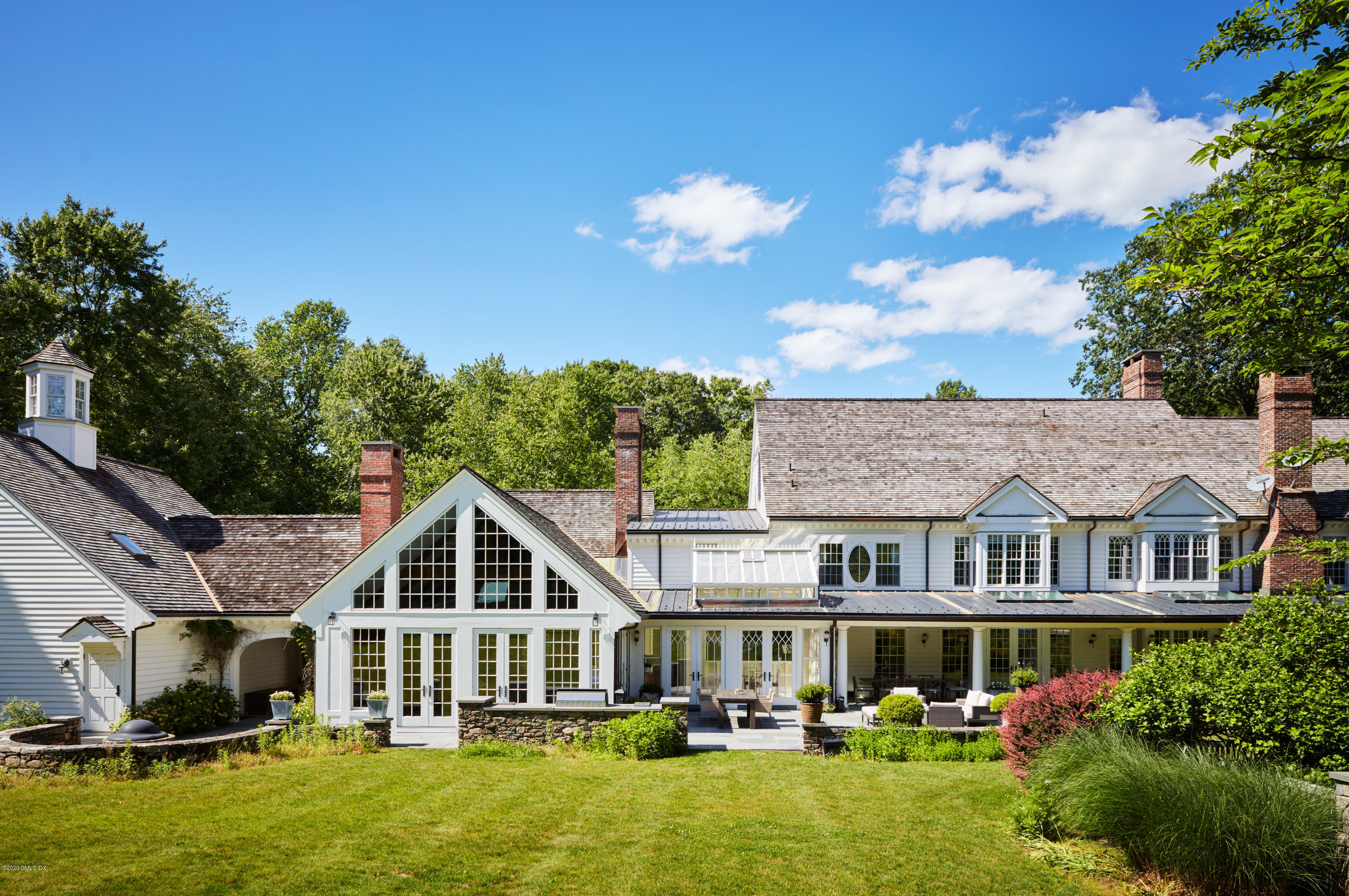 74 Upper Cross Road Greenwich, CT 06831 - Photo 17 of 20 a front view of a house with a yard table and chairs