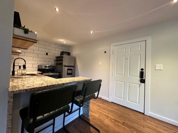 18333 Roehampton Drive, Unit 1524 Dallas, TX 75252 - Photo 18 of 21 a kitchen with granite countertop a sink cabinets and wooden floor