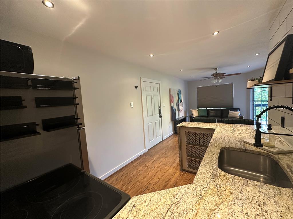 18333 Roehampton Drive, Unit 1524 Dallas, TX 75252 - Photo 20 of 21 a kitchen with granite countertop a sink and a stove top oven