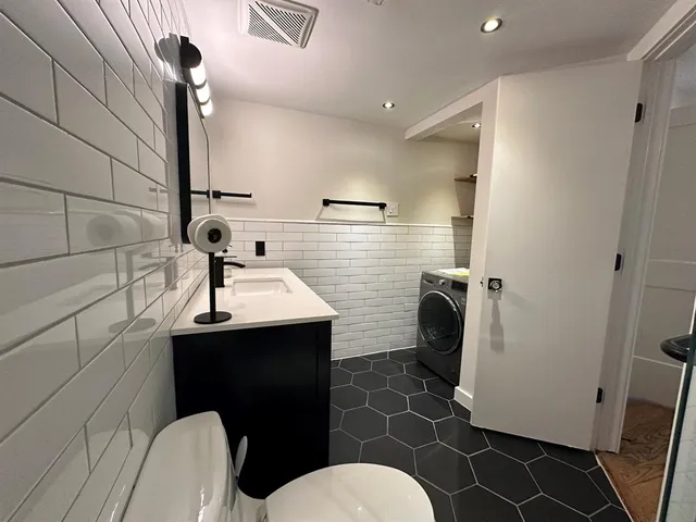 a bathroom with a sink toilet and mirror
