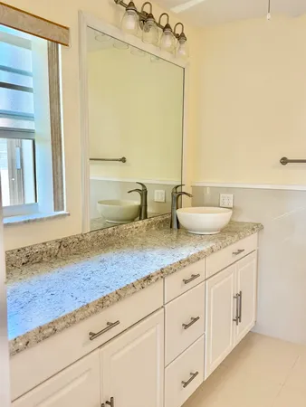 a bathroom with a granite countertop sink and a mirror