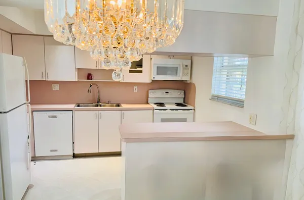 a kitchen with kitchen island a stove a sink and a refrigerator