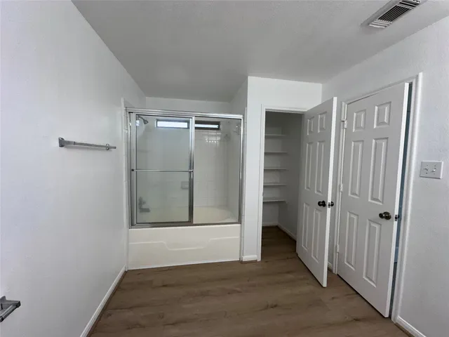 a spacious bathroom with a double vanity sink a toilet and a mirror