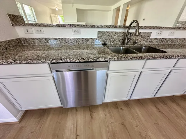 a kitchen with granite countertop a sink and a stove