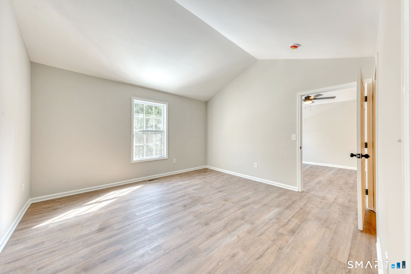 159 Jennifer Lane, Unit 159 Newtown, CT 06482 - Photo 18 of 28 a view of an empty room with wooden floor and a window