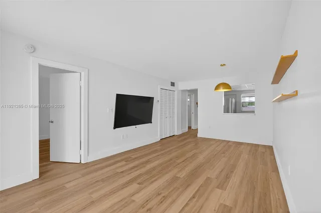 a view of a livingroom with wooden floor and a flat screen tv