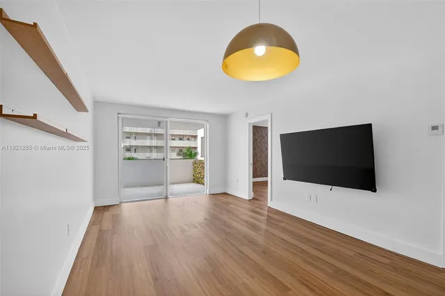 a view of a livingroom with wooden floor and cabinet