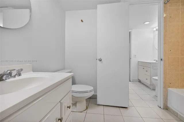a bathroom with a granite countertop toilet and sink