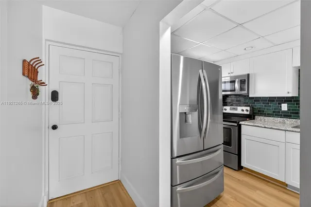 a kitchen with stainless steel appliances granite countertop a refrigerator and a stove top oven