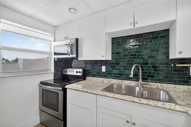 a kitchen with stainless steel appliances granite countertop a sink and a stove