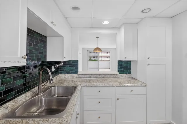 a kitchen with sink a stove and cabinets