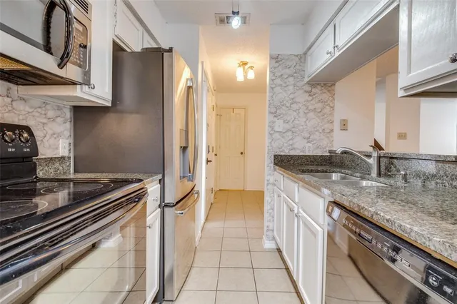a kitchen with stainless steel appliances granite countertop a sink stove and cabinets