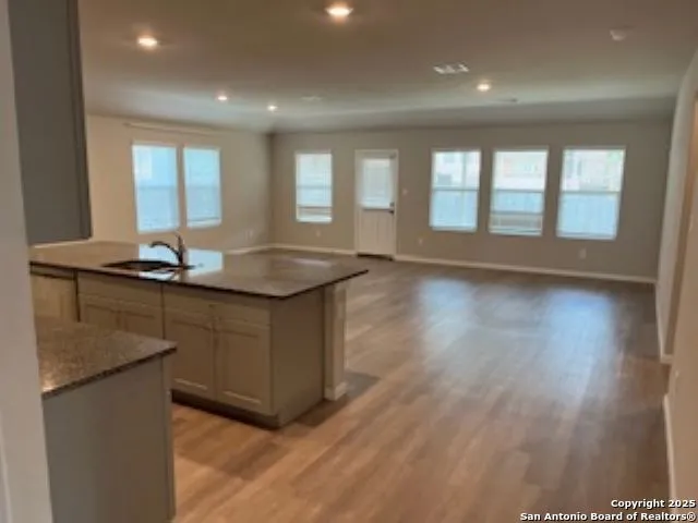 a kitchen with granite countertop a sink and a stove top oven
