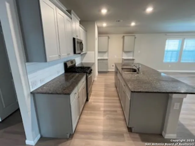 a kitchen with stainless steel appliances granite countertop a sink stove and refrigerator