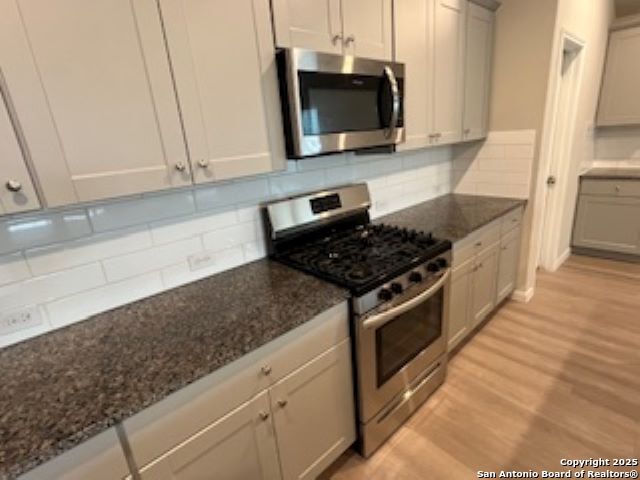 32132 Morels Avenue Bulverde, TX 78163 - Photo 6 of 13 a kitchen with stainless steel appliances granite countertop a sink a stove a microwave a counter space and cabinets