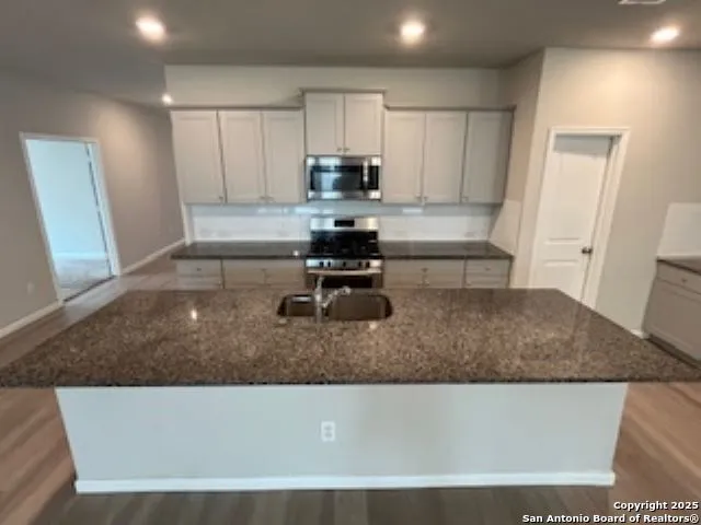 a kitchen with a sink a stove and cabinets