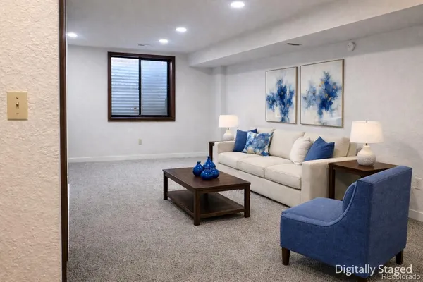 a living room with furniture and a wall painting