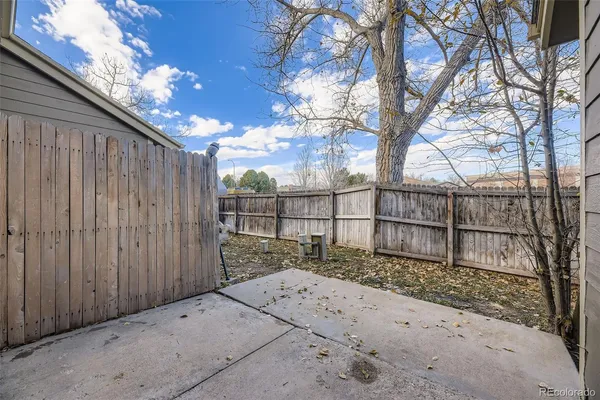 a view of backyard with wooden fence