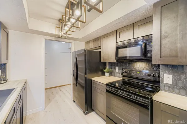 a kitchen with stainless steel appliances a sink stove and refrigerator
