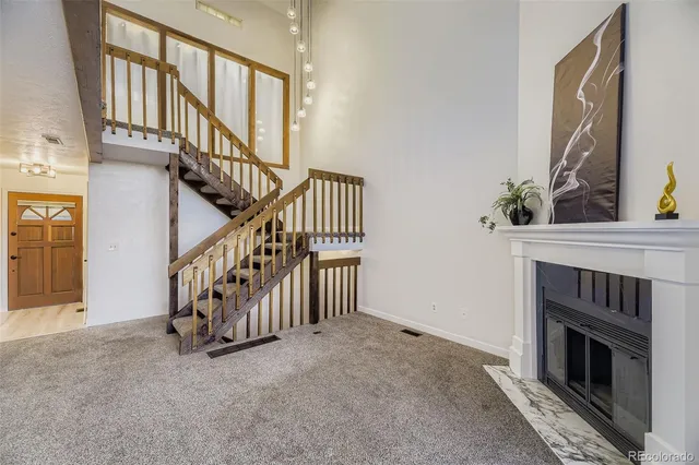 a view of an front door and a livingroom with a fireplace