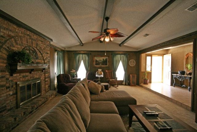 3802 70th Street Lubbock, TX 79413 - Photo 2 of 10 a living room with furniture a fireplace and a chandelier