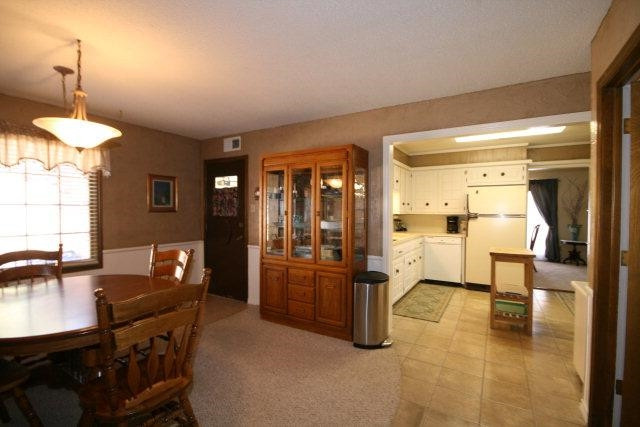 3802 70th Street Lubbock, TX 79413 - Photo 5 of 10 a kitchen with stainless steel appliances kitchen island granite countertop a refrigerator a stove and a dining table with a large window