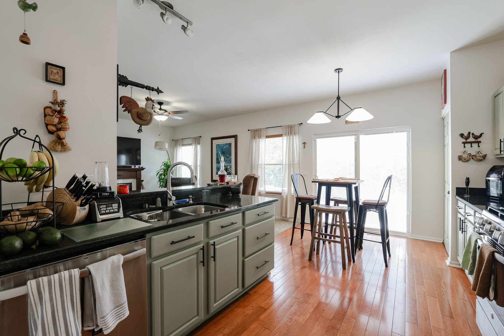 7 Michael Court Lake In The Hills, IL 60156 - Photo 9 of 37 a kitchen with granite countertop a stove a sink a dining table and chairs with wooden floor
