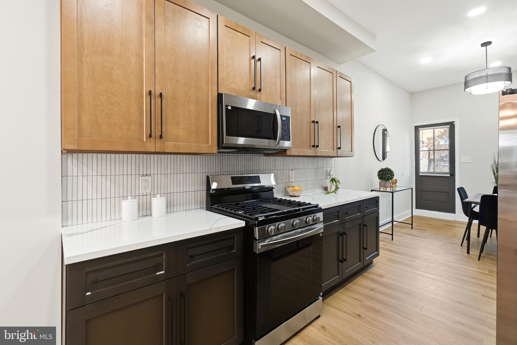 2237 Madison Avenue Baltimore, MD 21217 - Photo 23 of 53 a kitchen with stainless steel appliances granite countertop a stove a sink and a microwave