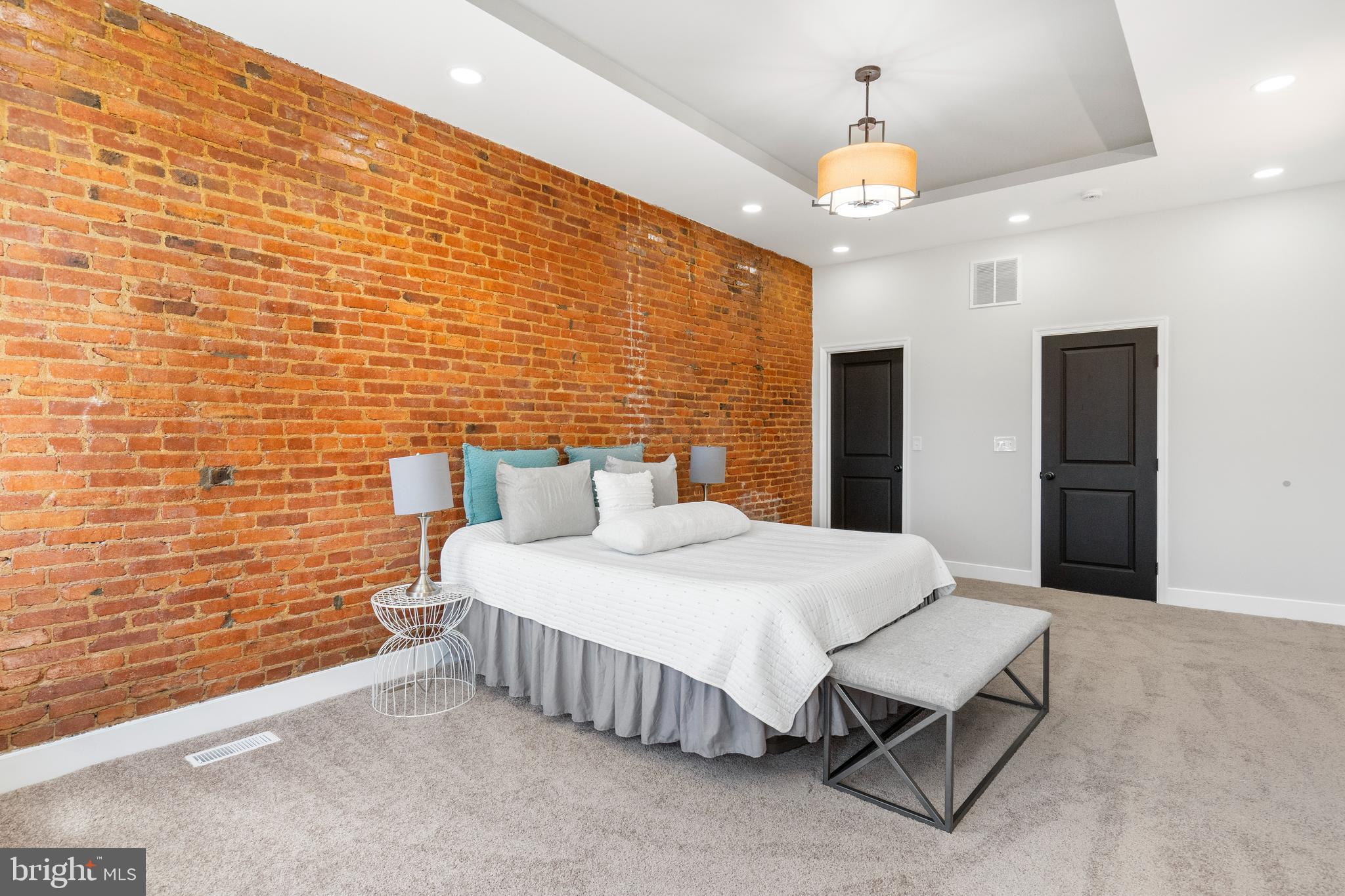 2237 Madison Avenue Baltimore, MD 21217 - Photo 33 of 53 a spacious bedroom with a bed and a chandelier