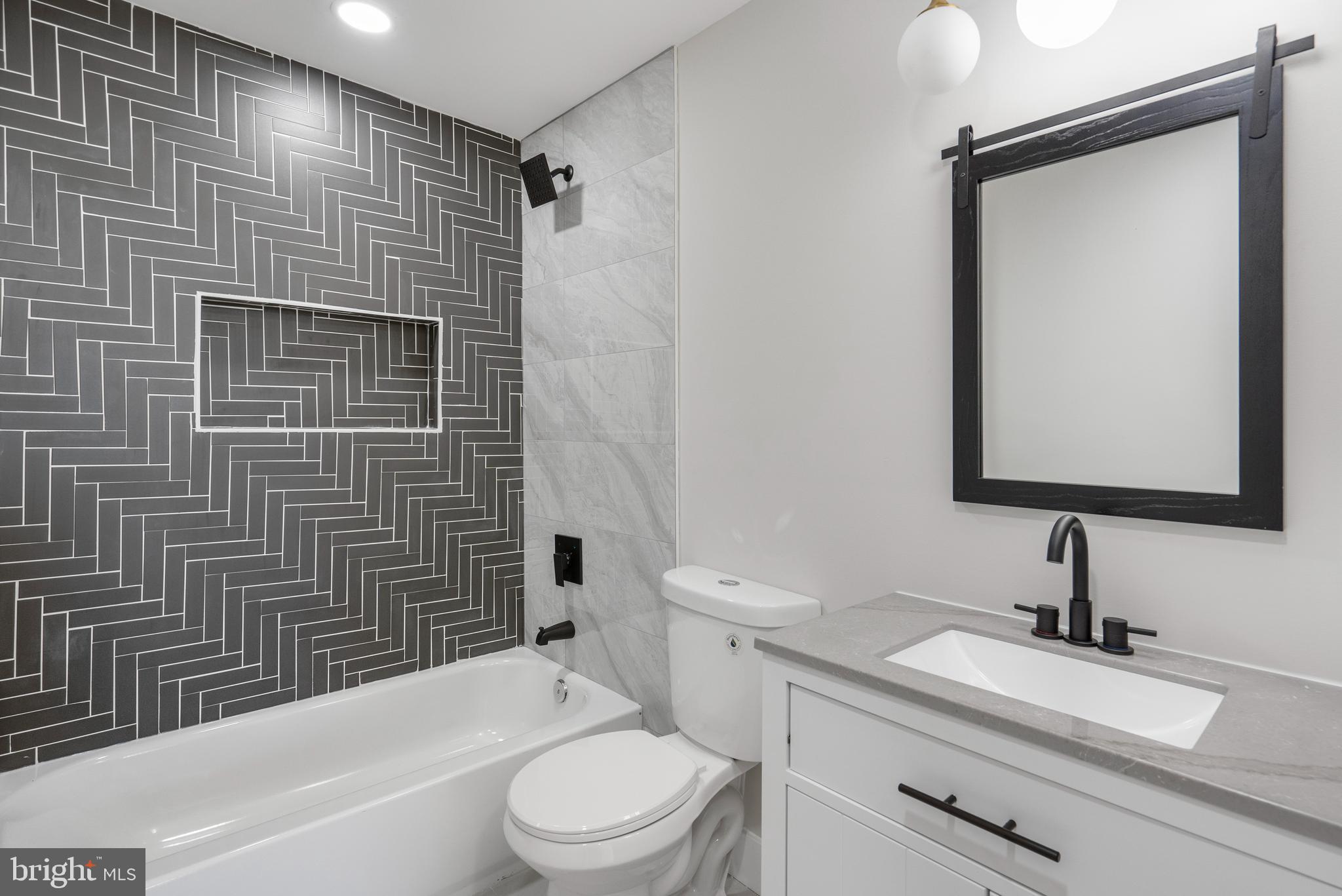 2237 Madison Avenue Baltimore, MD 21217 - Photo 50 of 53 a bathroom with a granite countertop toilet sink and mirror