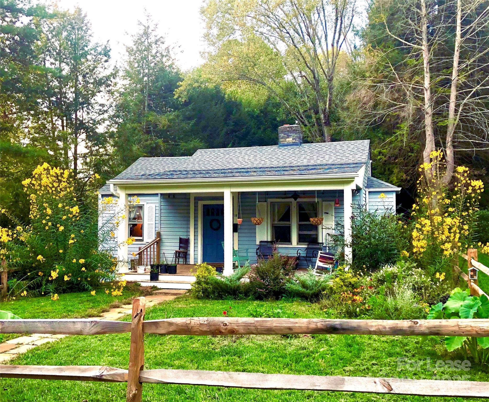 a view of a white house with large windows and a table and chairs