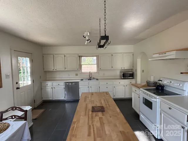 a kitchen with a white cabinets and window
