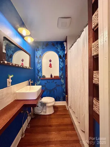 a bathroom with a sink a toilet and a mirror