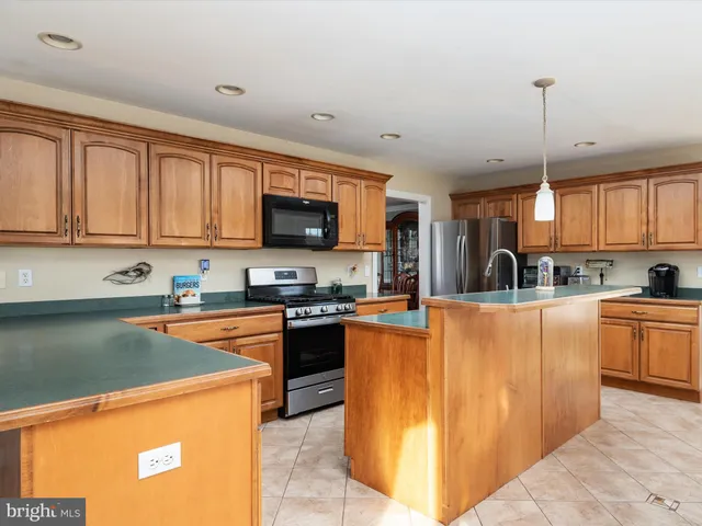 a kitchen with stainless steel appliances granite countertop a refrigerator a stove top oven a sink and dishwasher