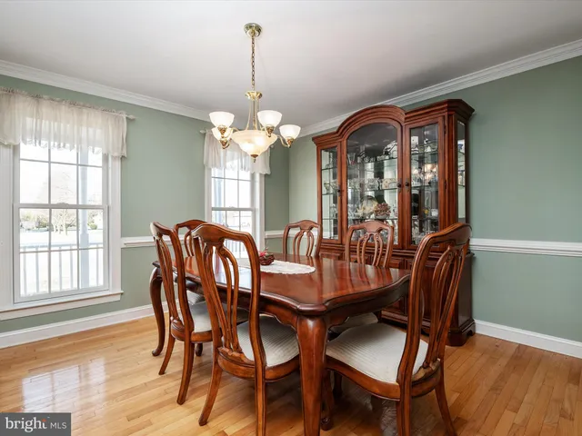 a dining room with furniture a chandelier and wooden floor