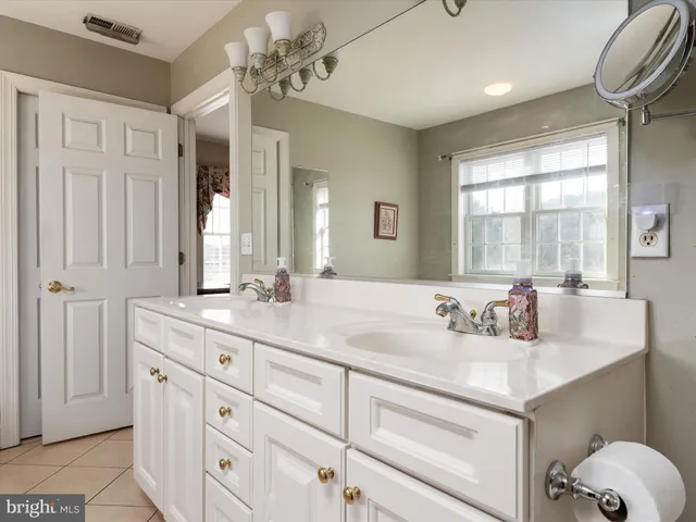 a spacious bedroom with a bed a dresser and a window