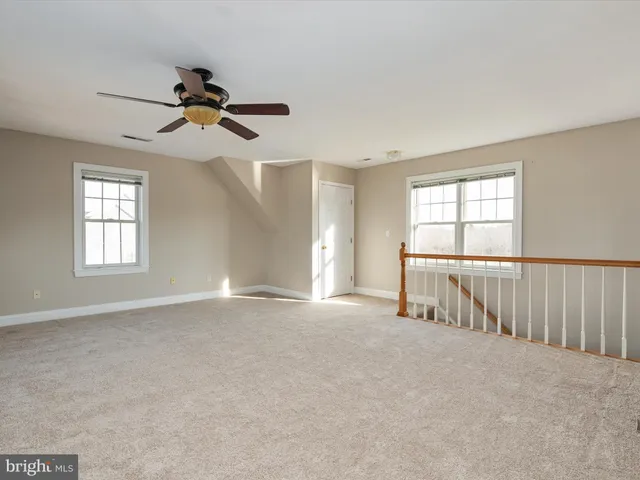 an empty room with windows and cabinet