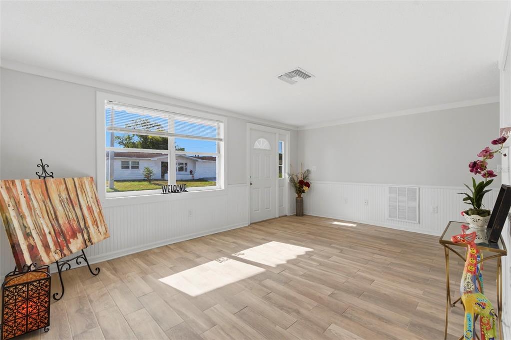 9033 Pegasus Avenue Port Richey, FL 34668 - Photo 5 of 56 a view of an empty room with a window and wooden floor