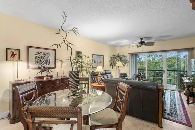 a living room with furniture a flat screen tv and a floor to ceiling window