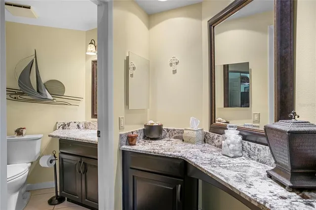 a bathroom with a granite countertop sink a toilet and a mirror