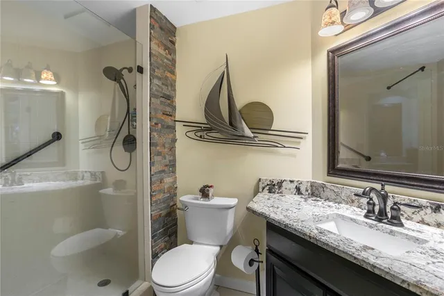 a bathroom with a granite countertop sink toilet and shower