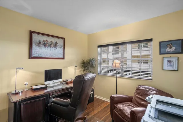 a view of a workspace with furniture and a window