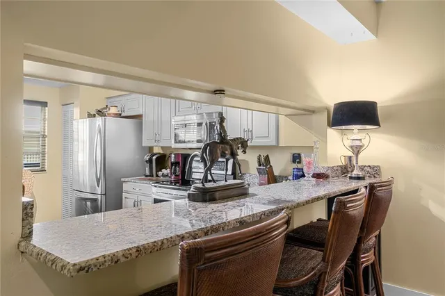 a kitchen with stainless steel appliances granite countertop a sink and refrigerator
