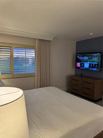a bedroom with a bed and a television