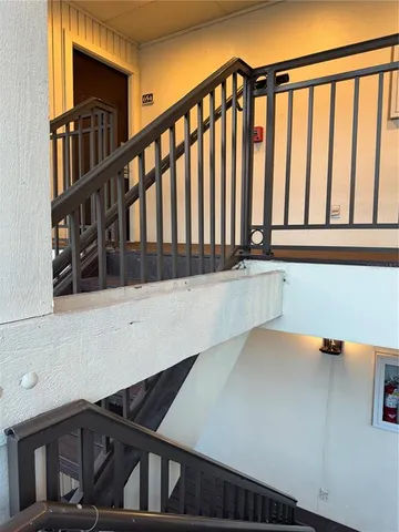 a view of staircase with railing and a window