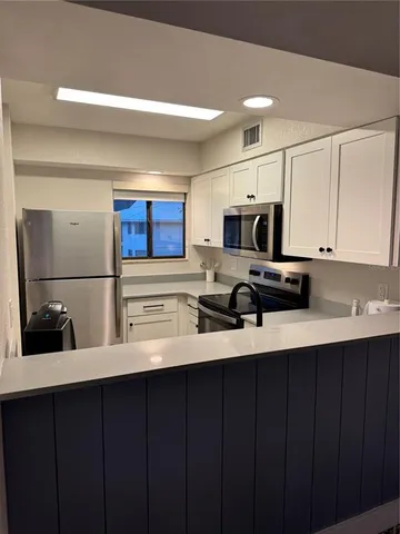 a kitchen with a sink a microwave and cabinets